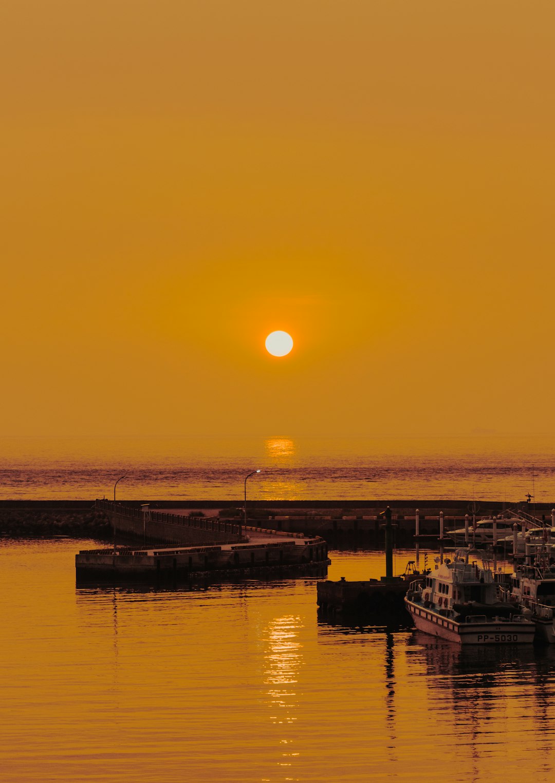 silhouette of boat on sea during sunset