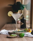 clear martini glass with sliced lemon on brown wooden table