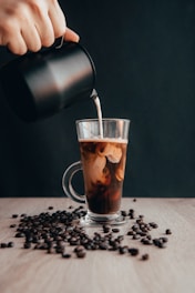 clear glass mug with coffee beans