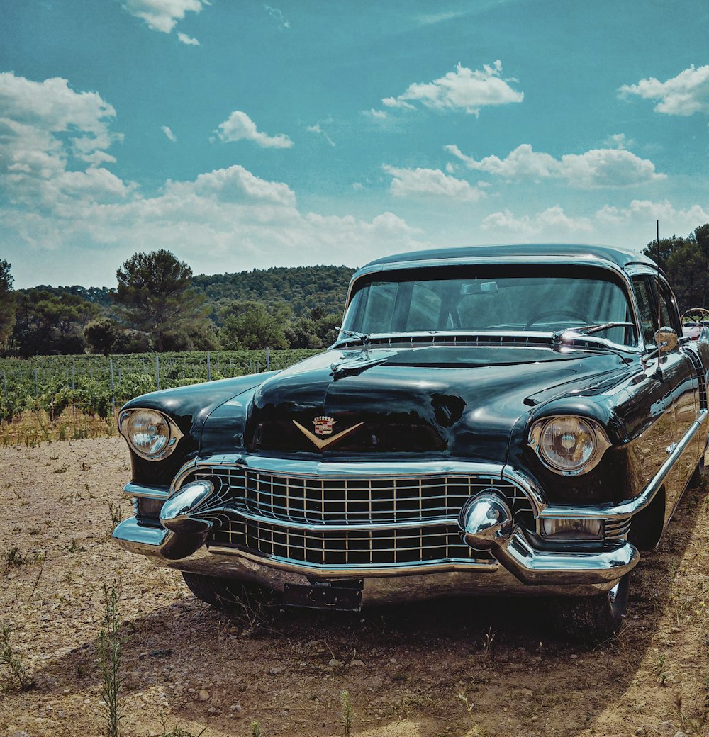 blue classic car on brown field under blue sky during daytime