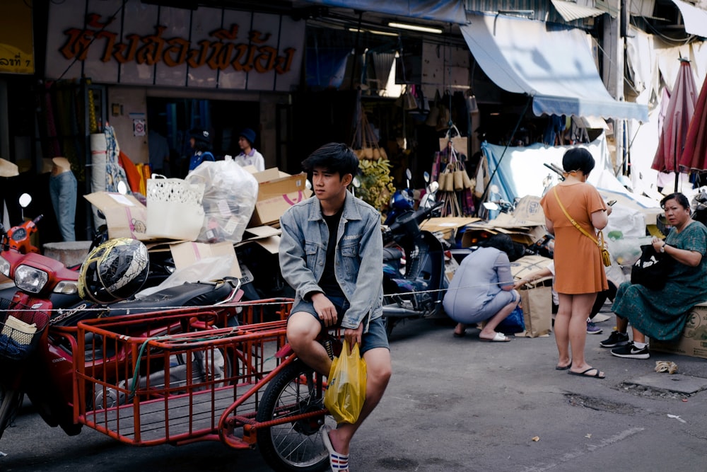 a man sitting on a red cart in front of a store