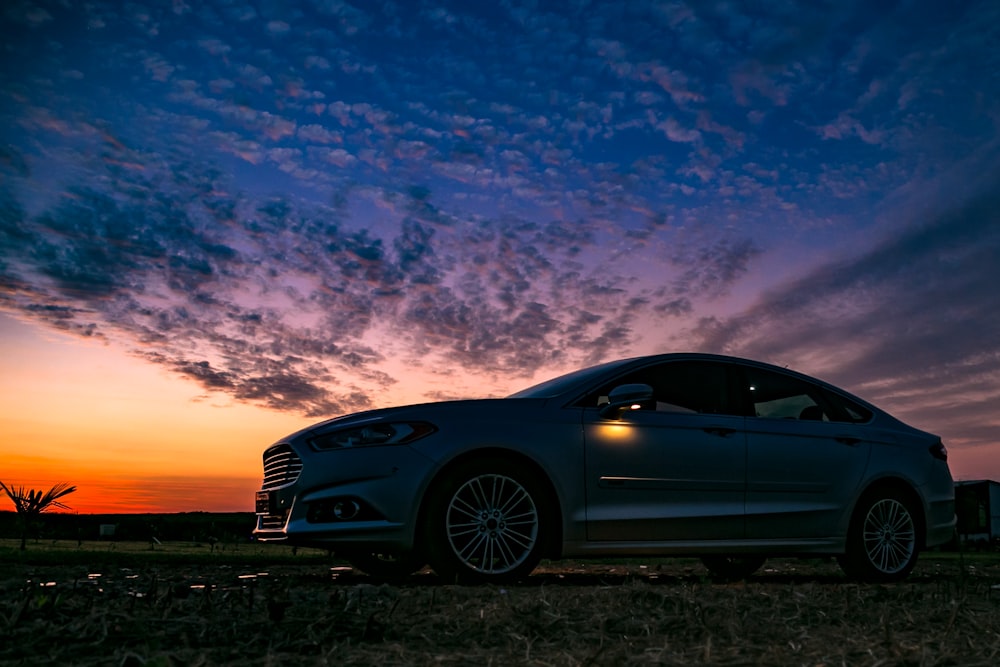 blue bmw m 3 coupe on brown field under blue and white cloudy sky during daytime