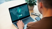 person using macbook pro on white table