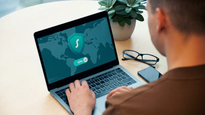 person using macbook pro on white table