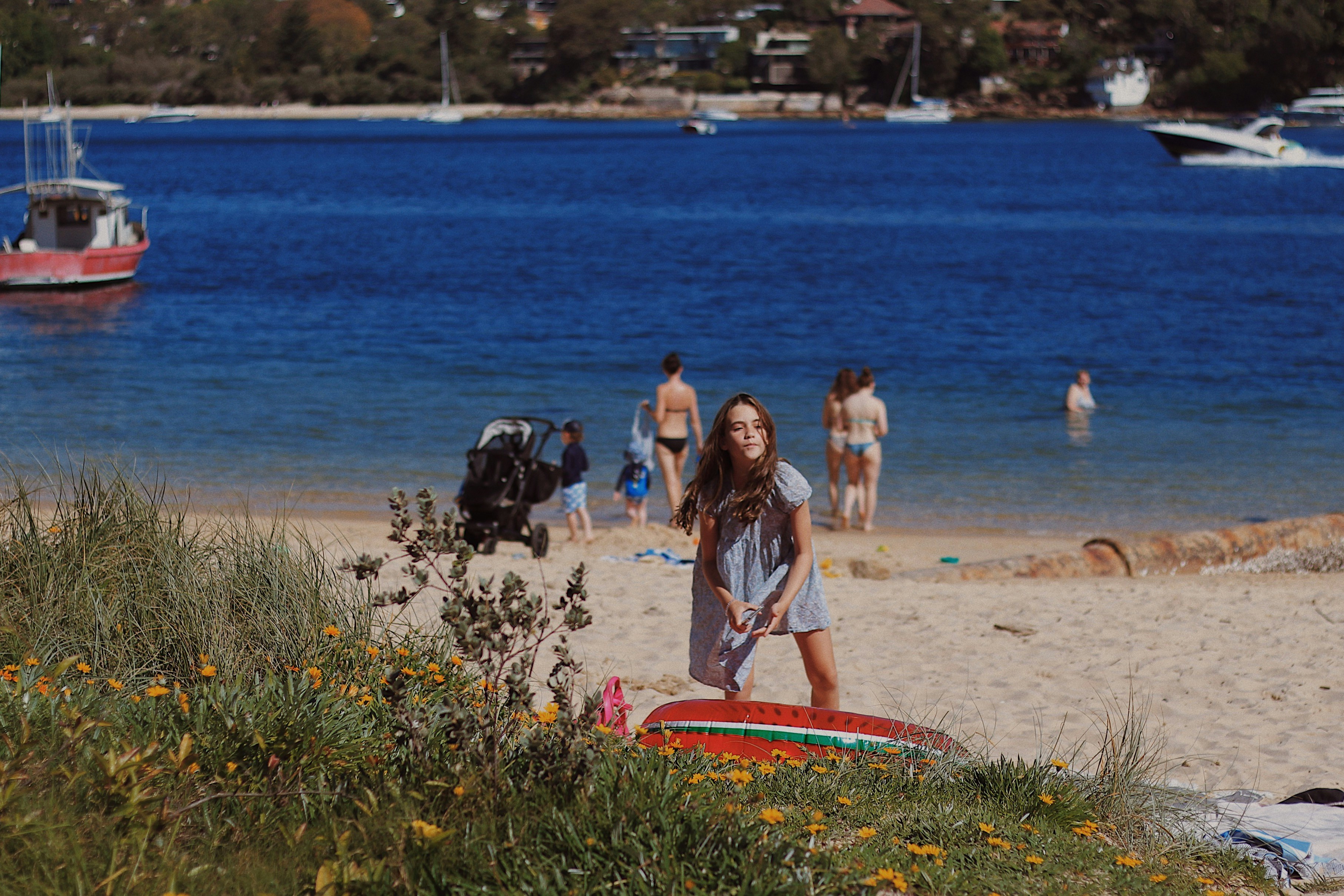 A woman standing on a beach next to a body of water photo – Free ...