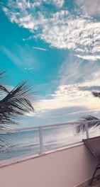 A scenic view from a hotel balcony overlooking the ocean.