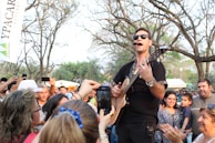 Just esmond smiling with fans after an intimate acoustic set outdoors.