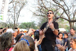 A lively outdoor performance featuring a student strumming confidently