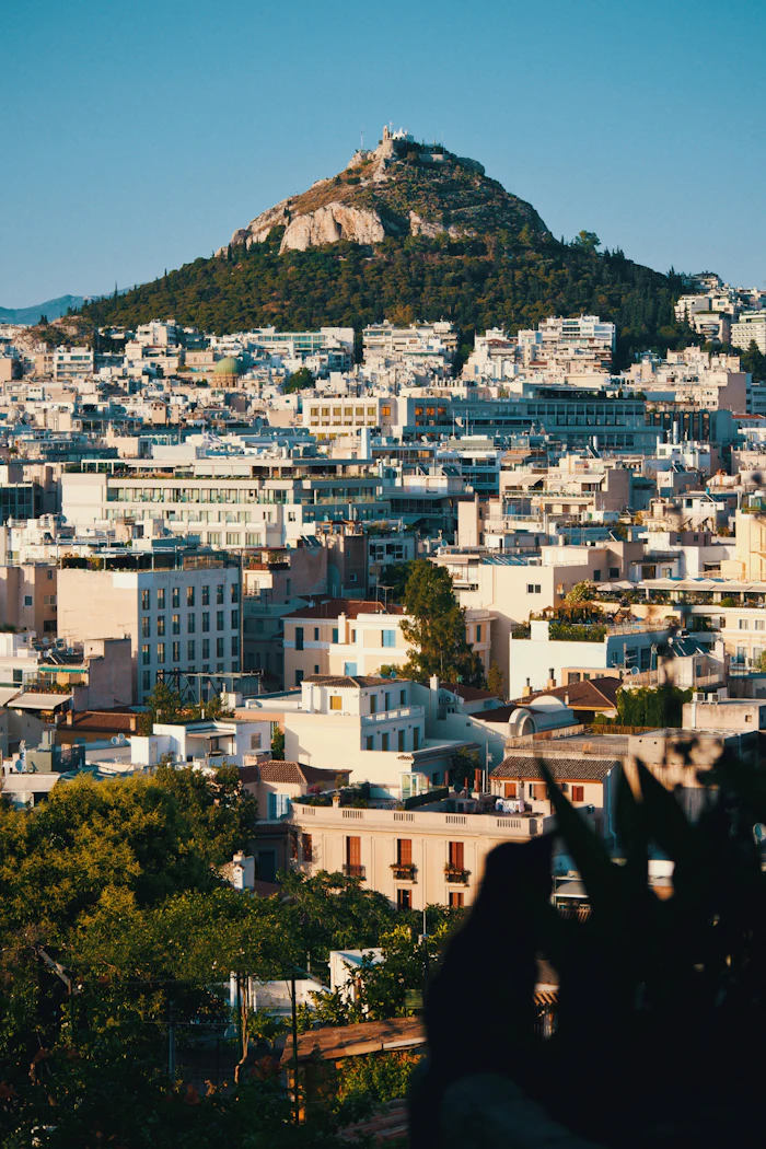 Lycabettus above the rooftops, the city climbing towards it.