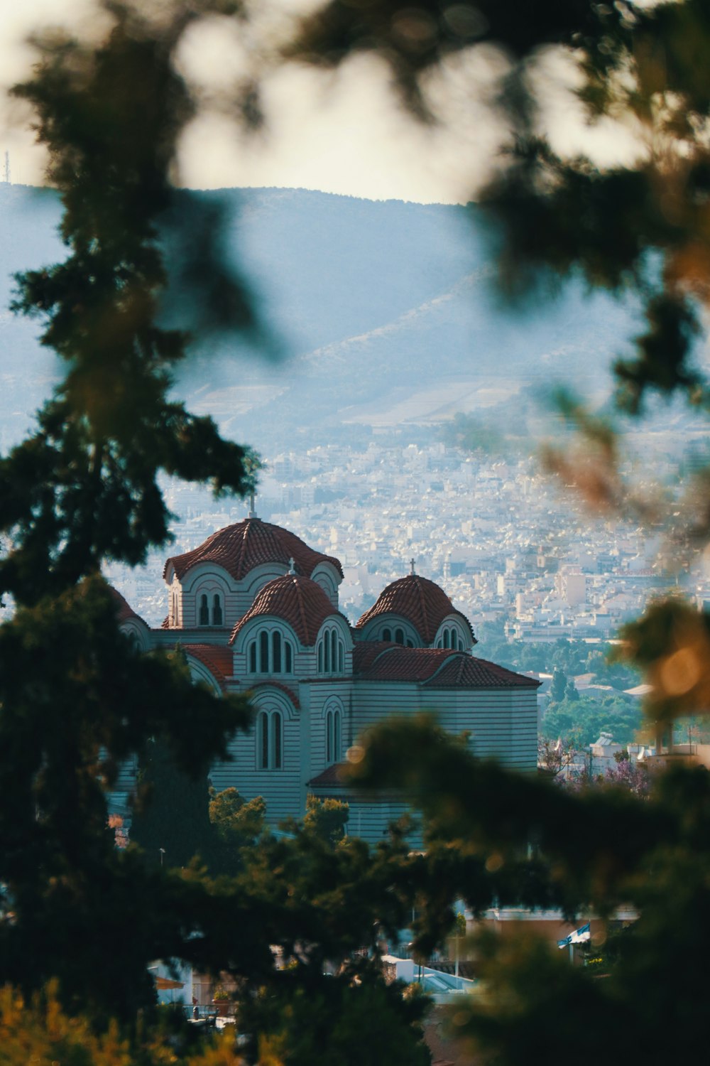 white and brown concrete building near green trees during daytime