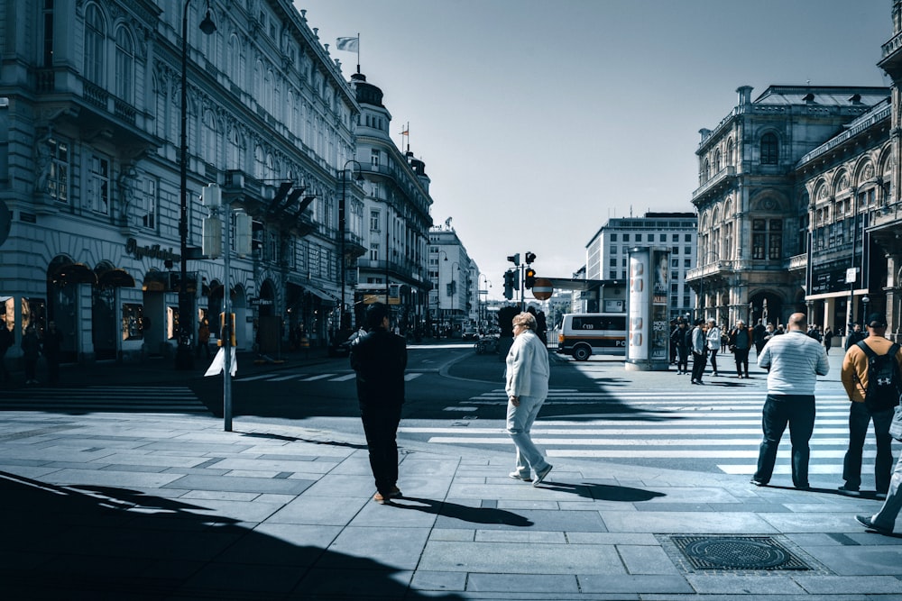 man in white jacket and pants walking on sidewalk during daytime