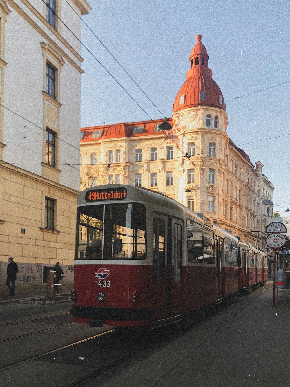 red and yellow tram on road near brown concrete building during daytime