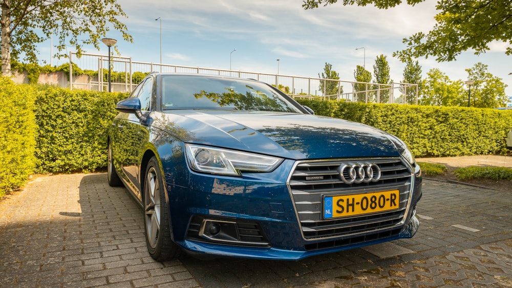 blue audi a 4 parked on gray brick pavement during daytime