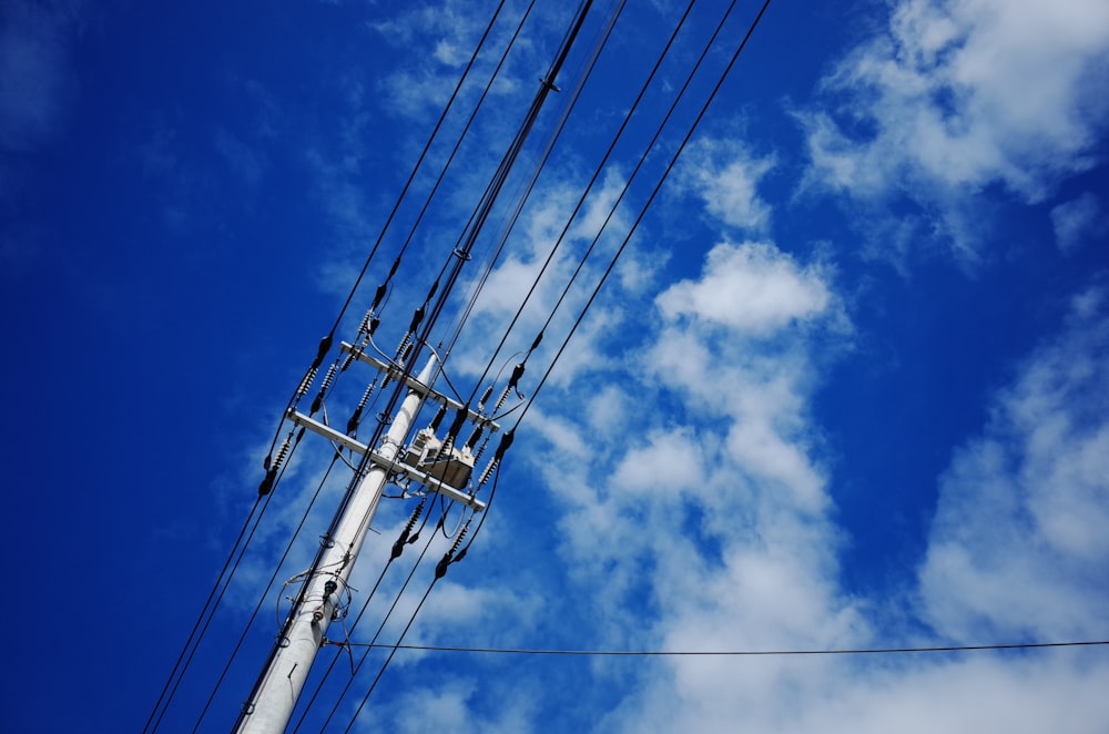 black electric post under blue sky