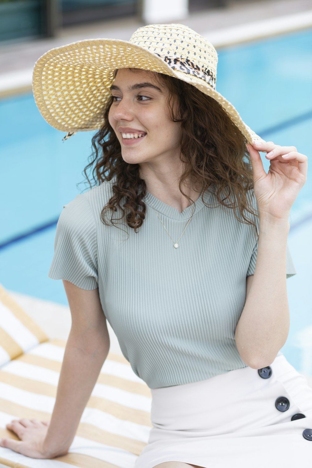 茶色の麦わら帽子をかぶった白と青の縞模様のドレスを着た女性