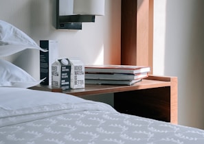 Soft-focus image of a bedside table topped with soothing personal care items illuminated by morning sunlight.