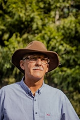 man in gray button up shirt wearing brown fedora hat