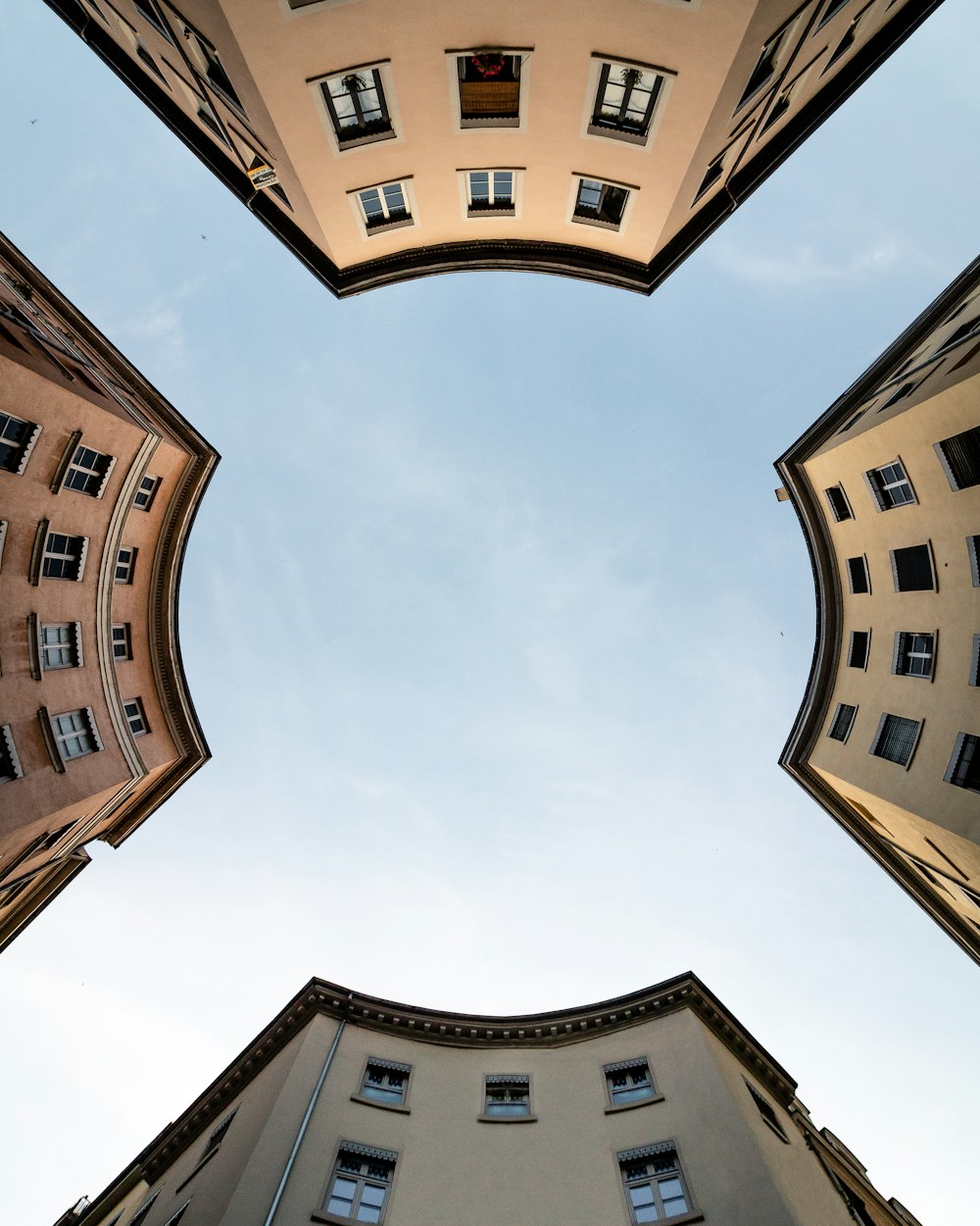 Fotografía de ángulo bajo de un edificio de hormigón marrón bajo nubes blancas durante el día