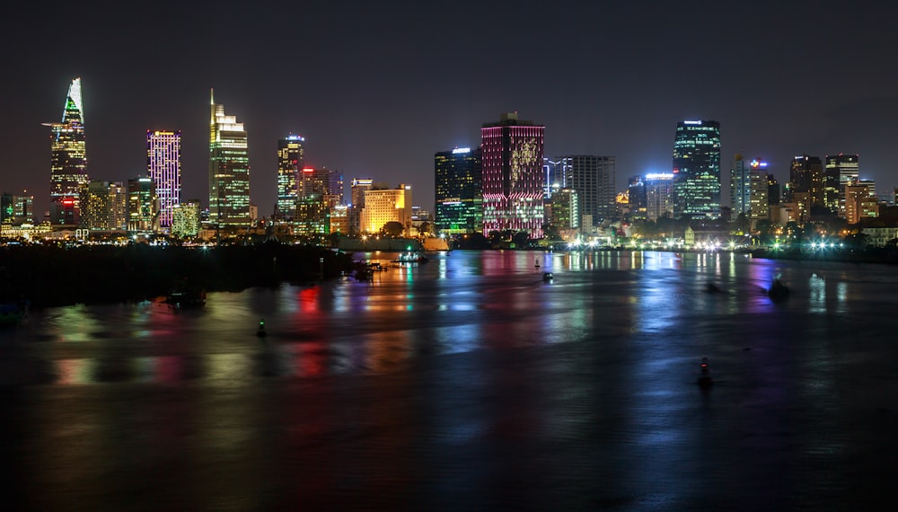 a city at night with lights reflecting off the water