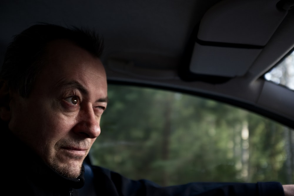 man in blue hoodie inside car