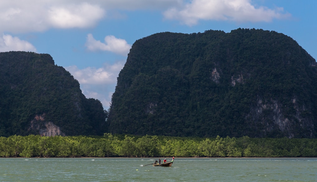 a man in a small boat on a large body of water