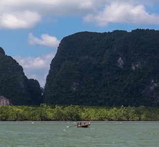 a man in a small boat on a large body of water