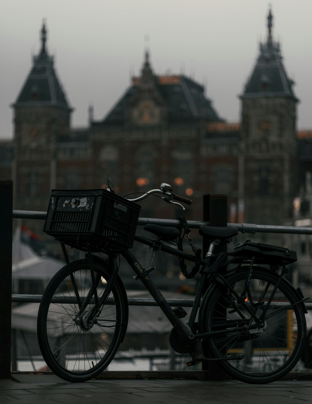 Vélo noir garé à côté d’une clôture en acier noir pendant la journée