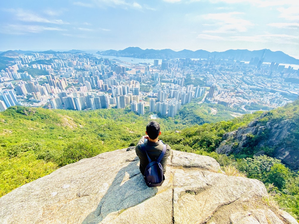 a person sitting on top of a large rock