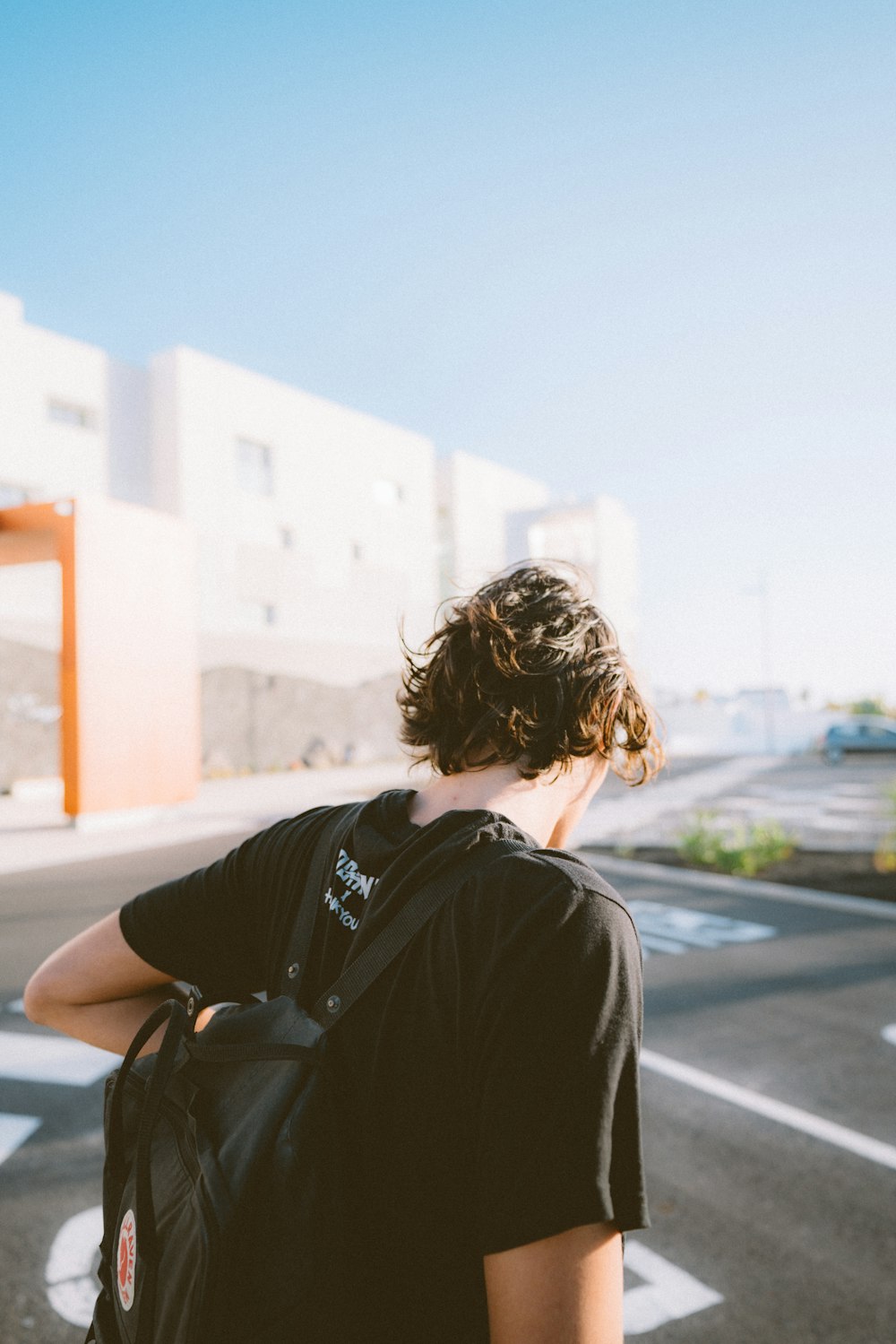 man in black shirt sitting on the road during daytime