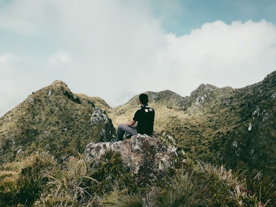 man in black shirt sitting on rock during daytime in Mount Apo Philippines