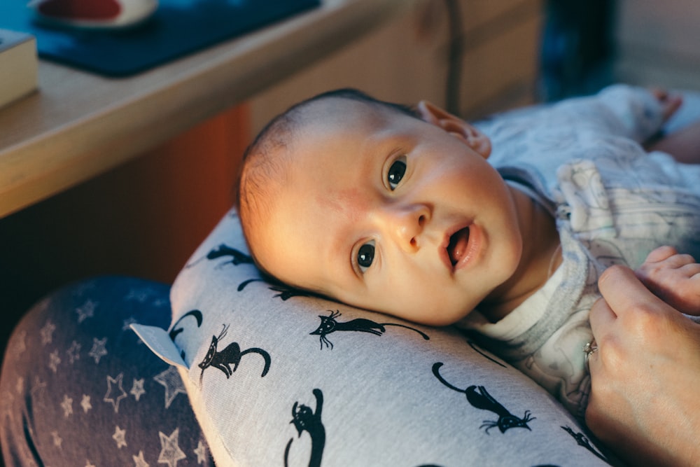 bebê na camisa branca deitado na cama