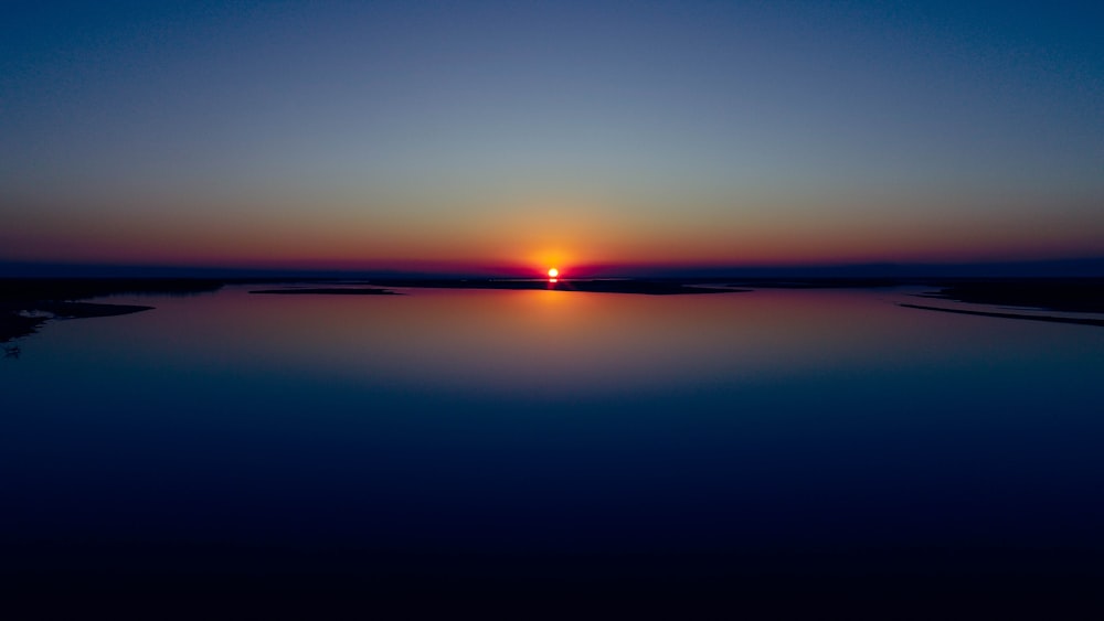 calm sea under blue sky during sunset