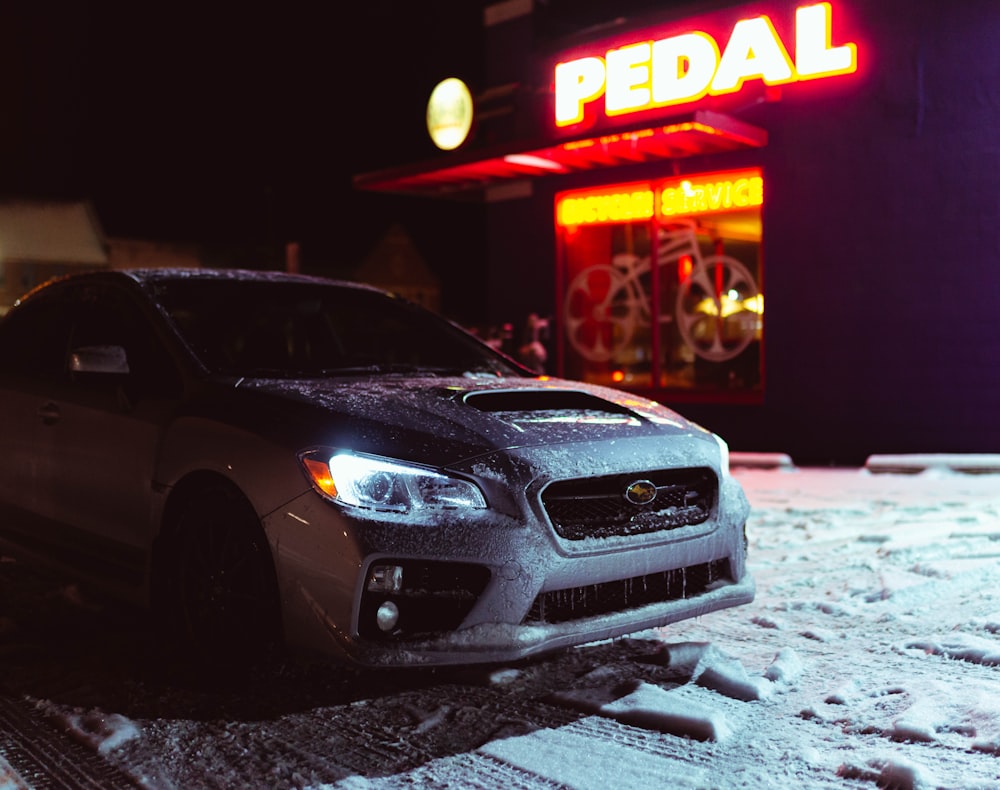 a car parked in front of a store at night