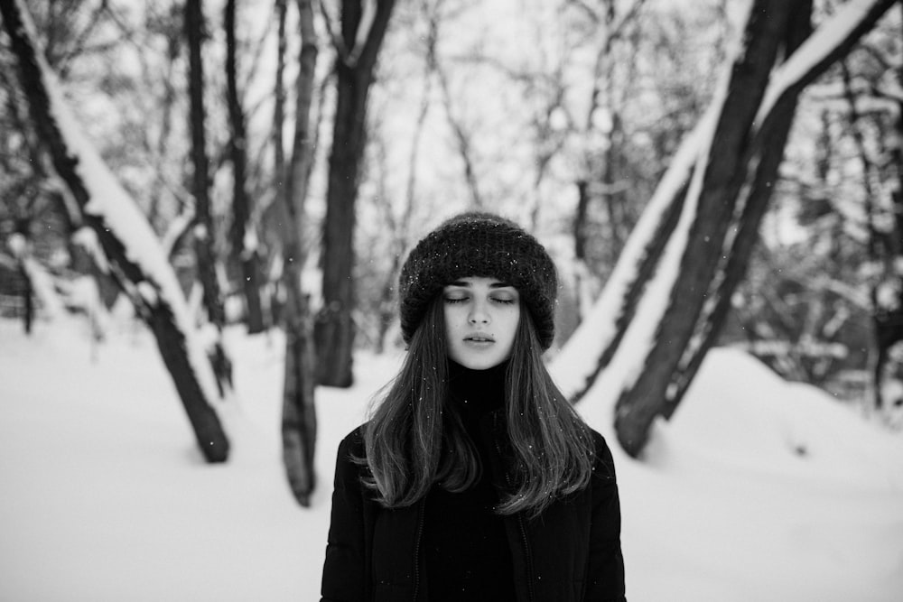 a woman standing in the snow with her eyes closed