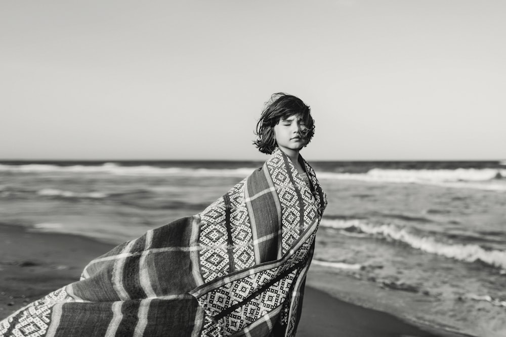woman in black and white scarf standing on beach during daytime