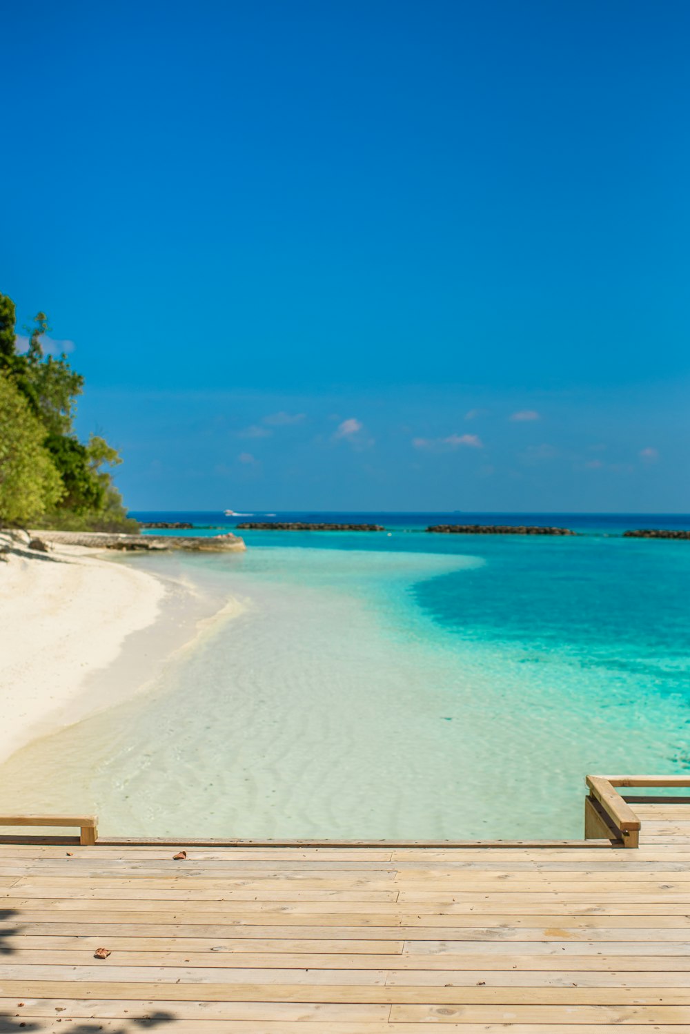 a wooden dock sitting on top of a sandy beach