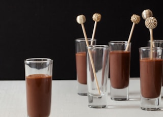 two clear drinking glasses with brown liquid