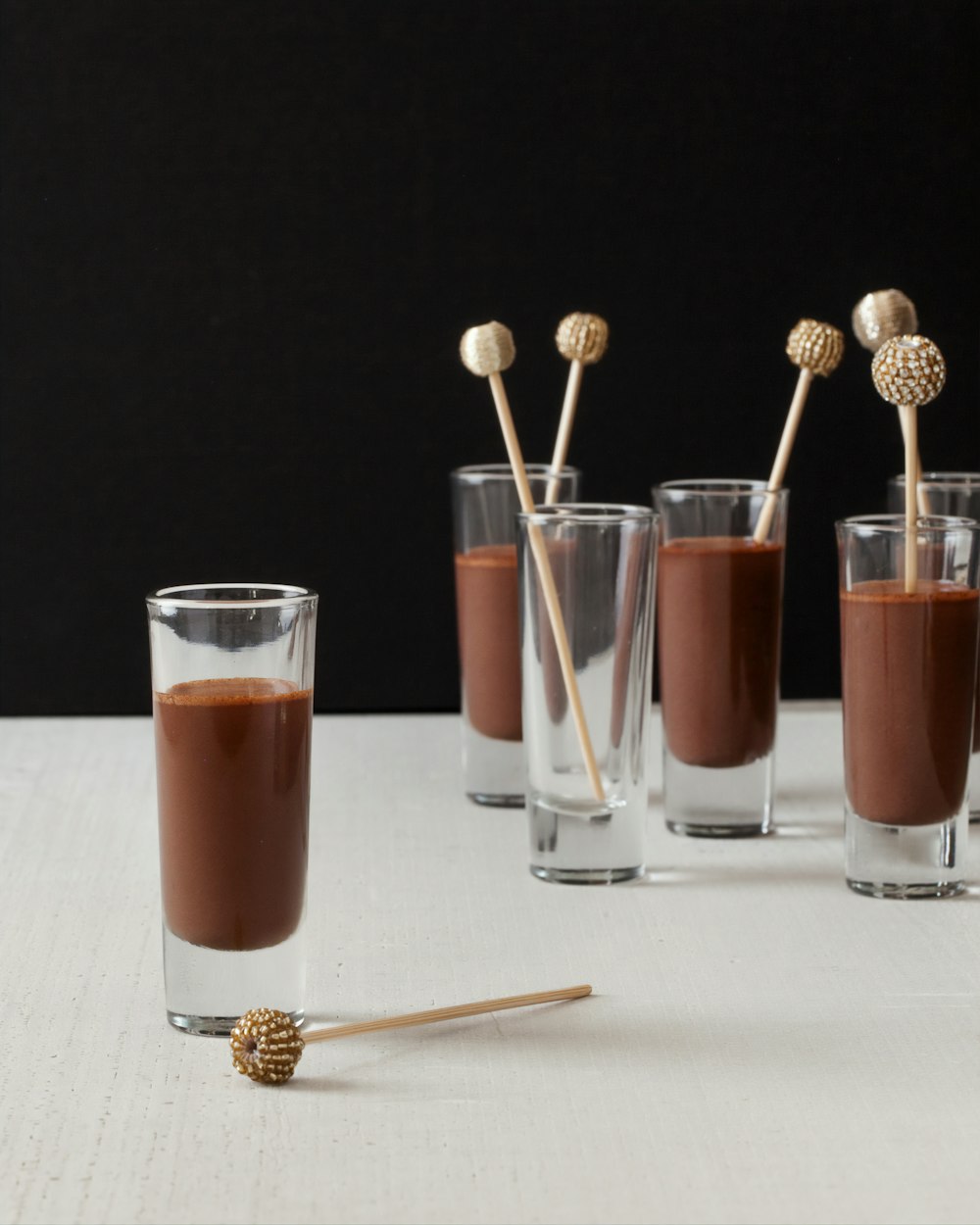 two clear drinking glasses with brown liquid