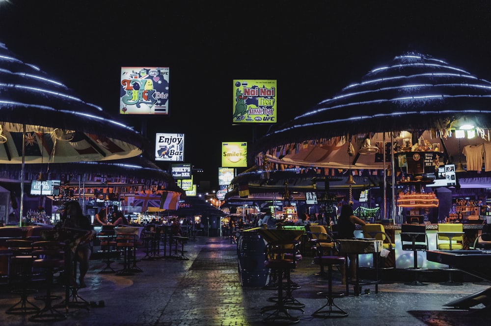 people sitting on chair near store during night time