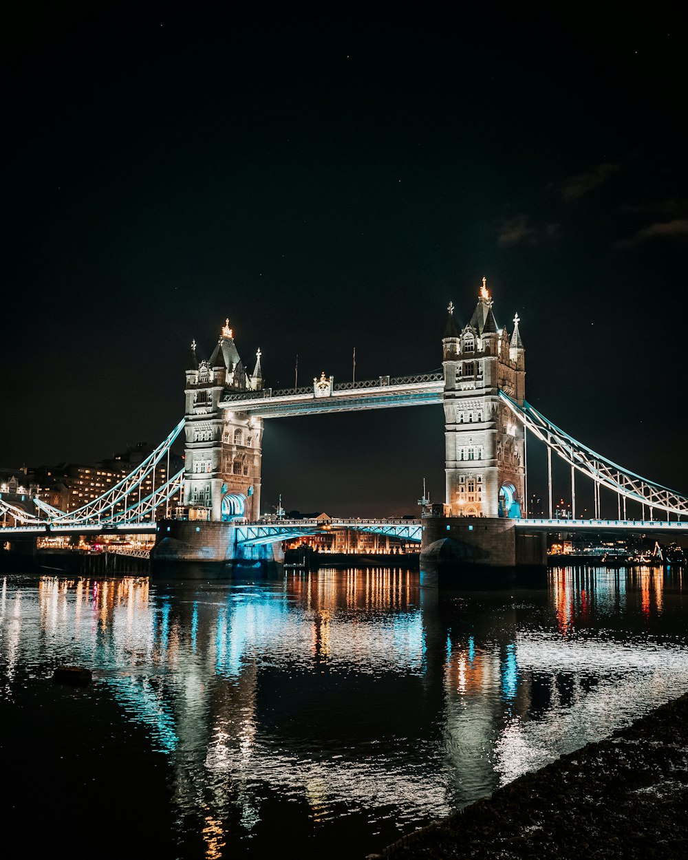 lighted bridge over water during night time