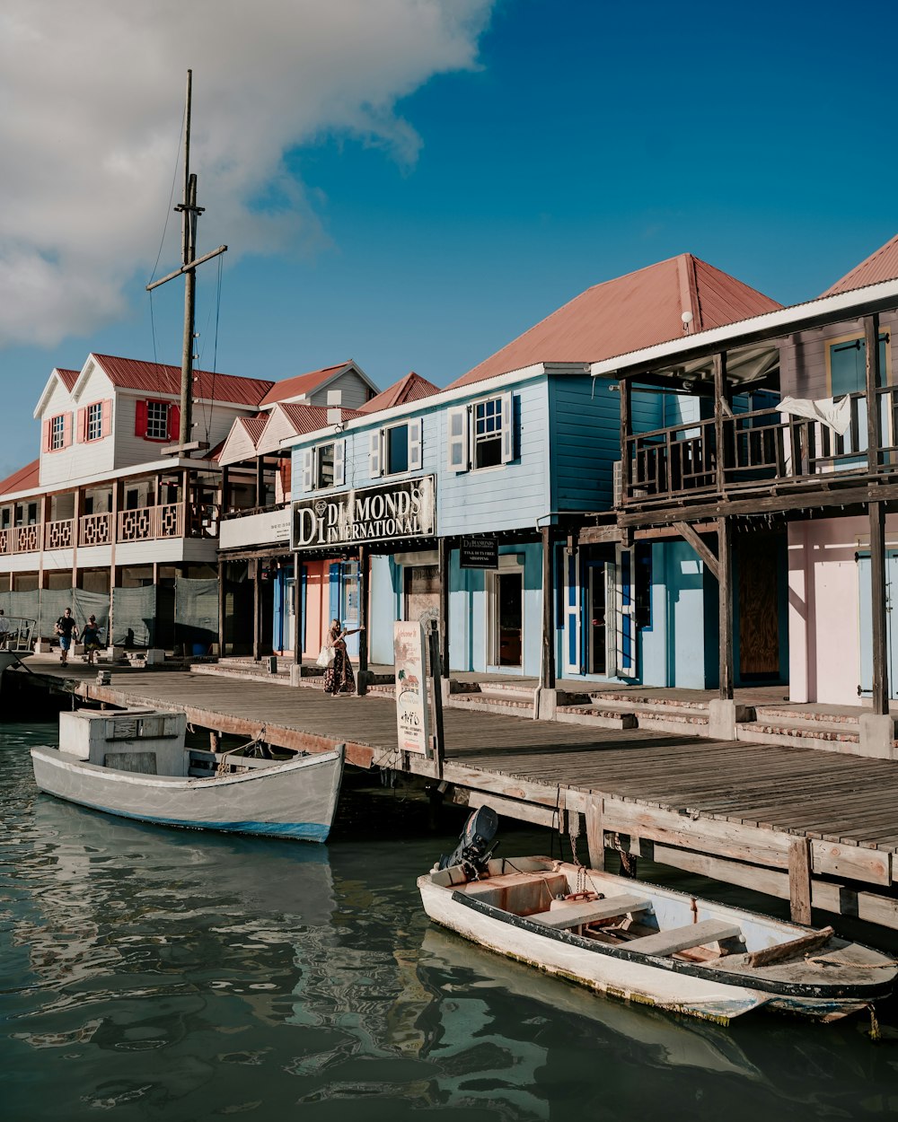 white and blue wooden house beside body of water during daytime