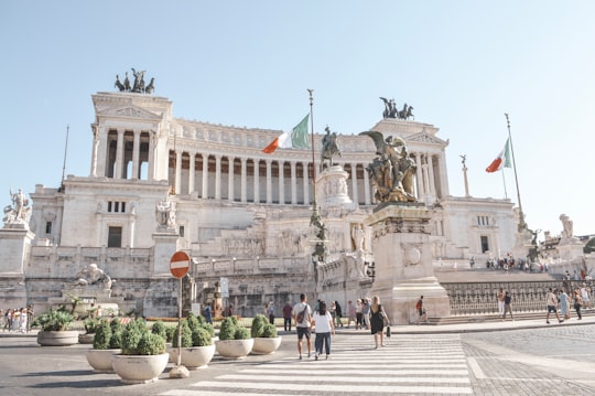 people walking on street near white concrete building during daytime in Piazza Venezia Italy
