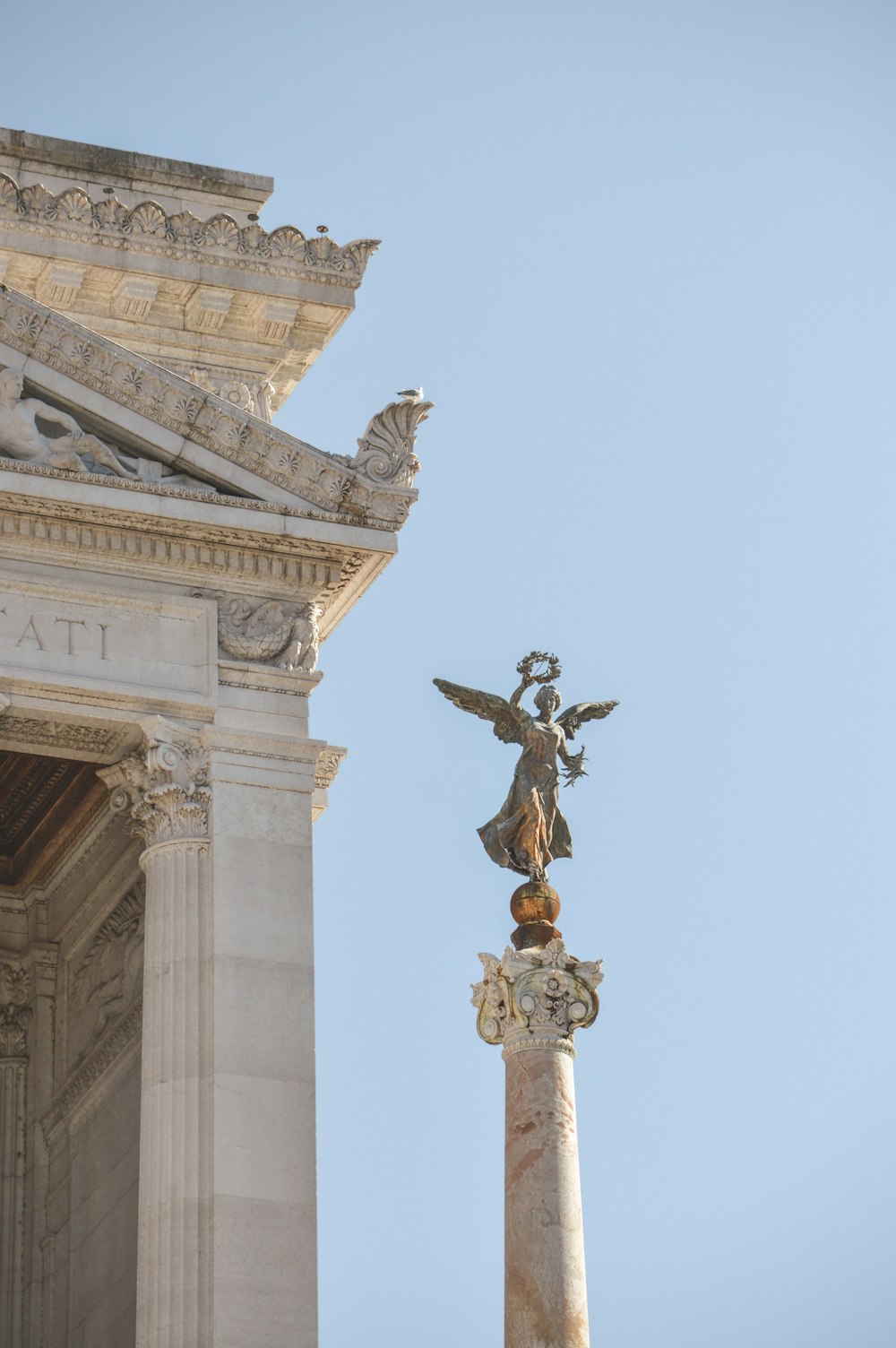 black and brown statue on top of white concrete building