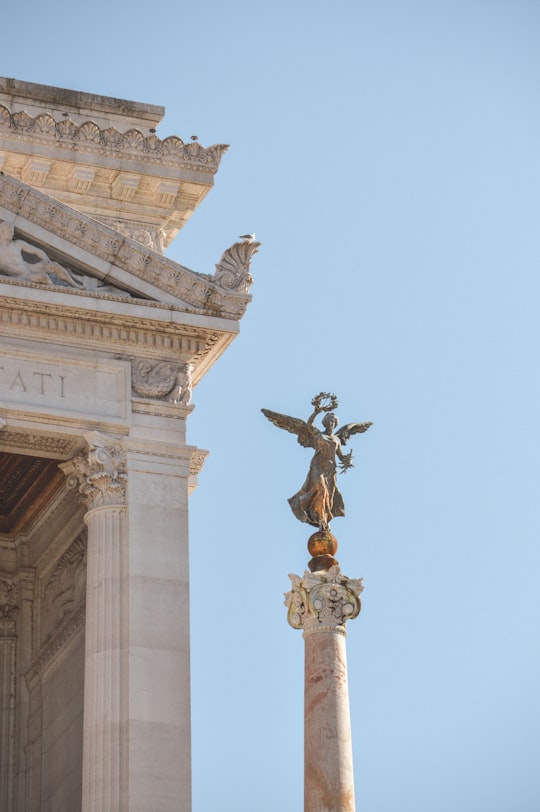 black and brown statue on top of white concrete building in Piazza Venezia Italy
