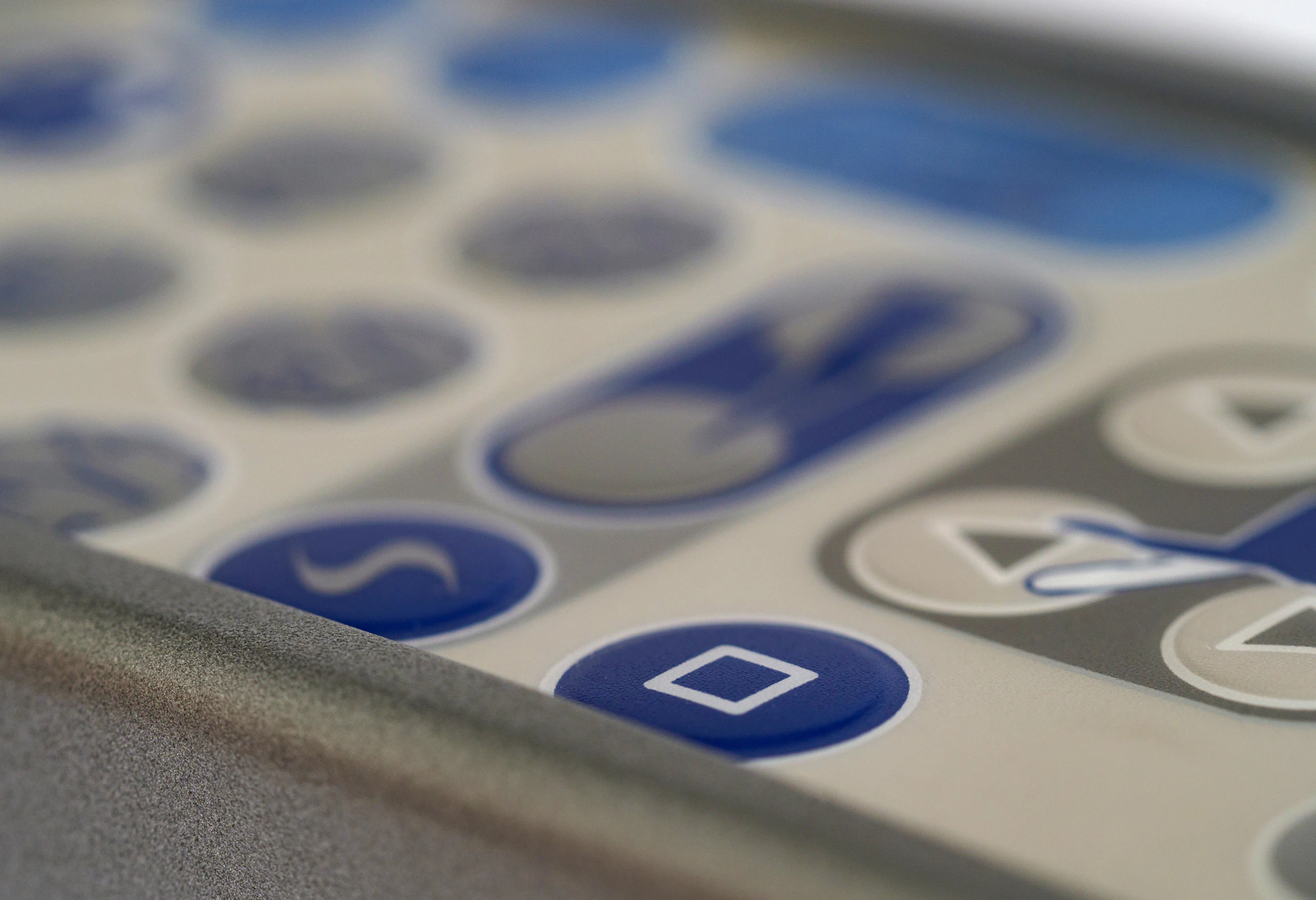 A close-up of a digital keypad access control system with illuminated blue buttons, set against a clean white surface.