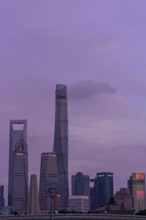 A sleek, modern cityscape at dusk with deep purple hues reflecting off glass buildings, capturing the essence of a premium PR agency.