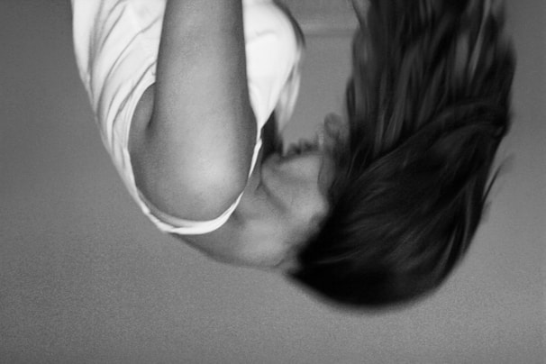 Black and white image of a model in motion, hair flowing, creating a dynamic feel.