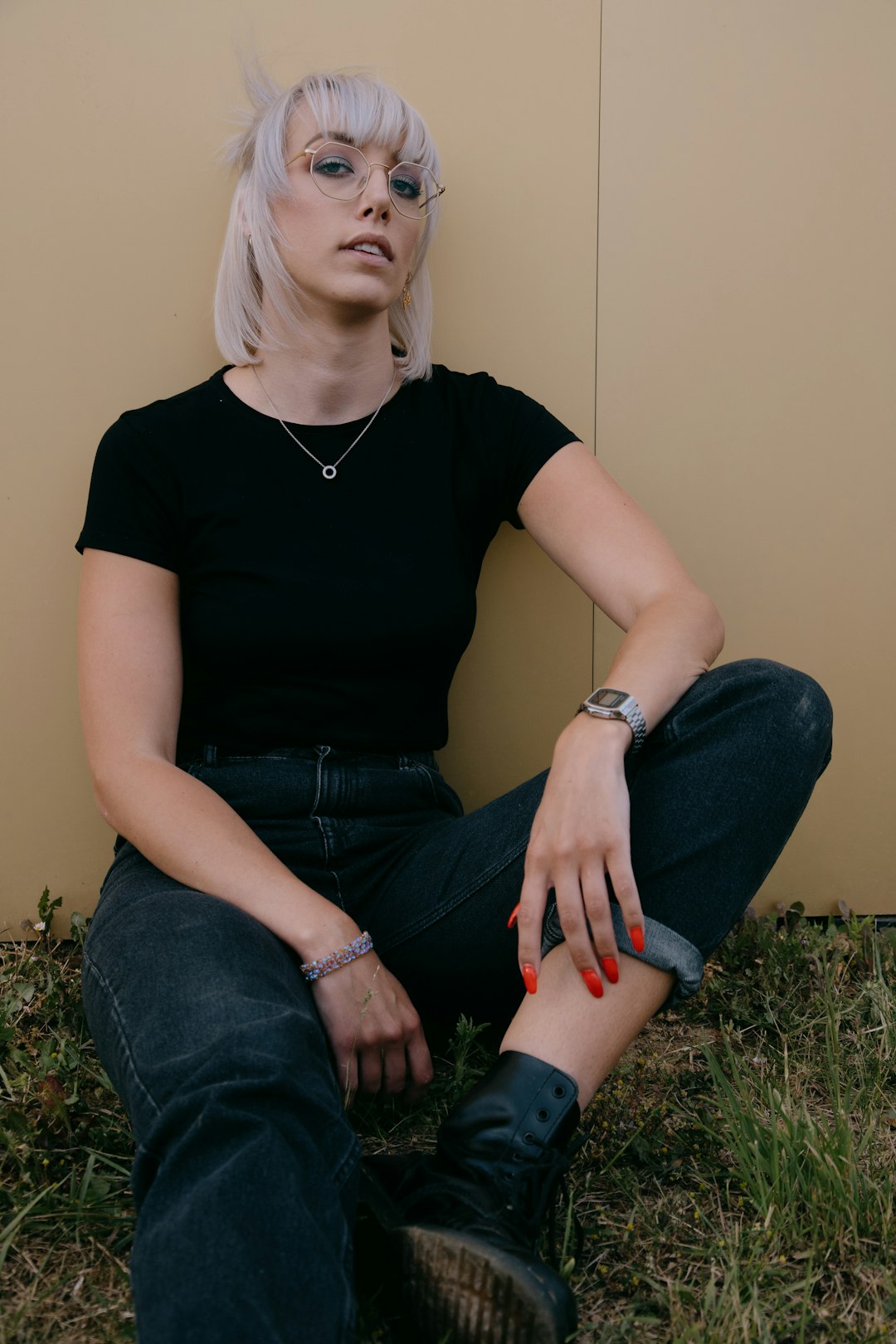 woman in black crew neck t-shirt and blue denim jeans sitting on green grass