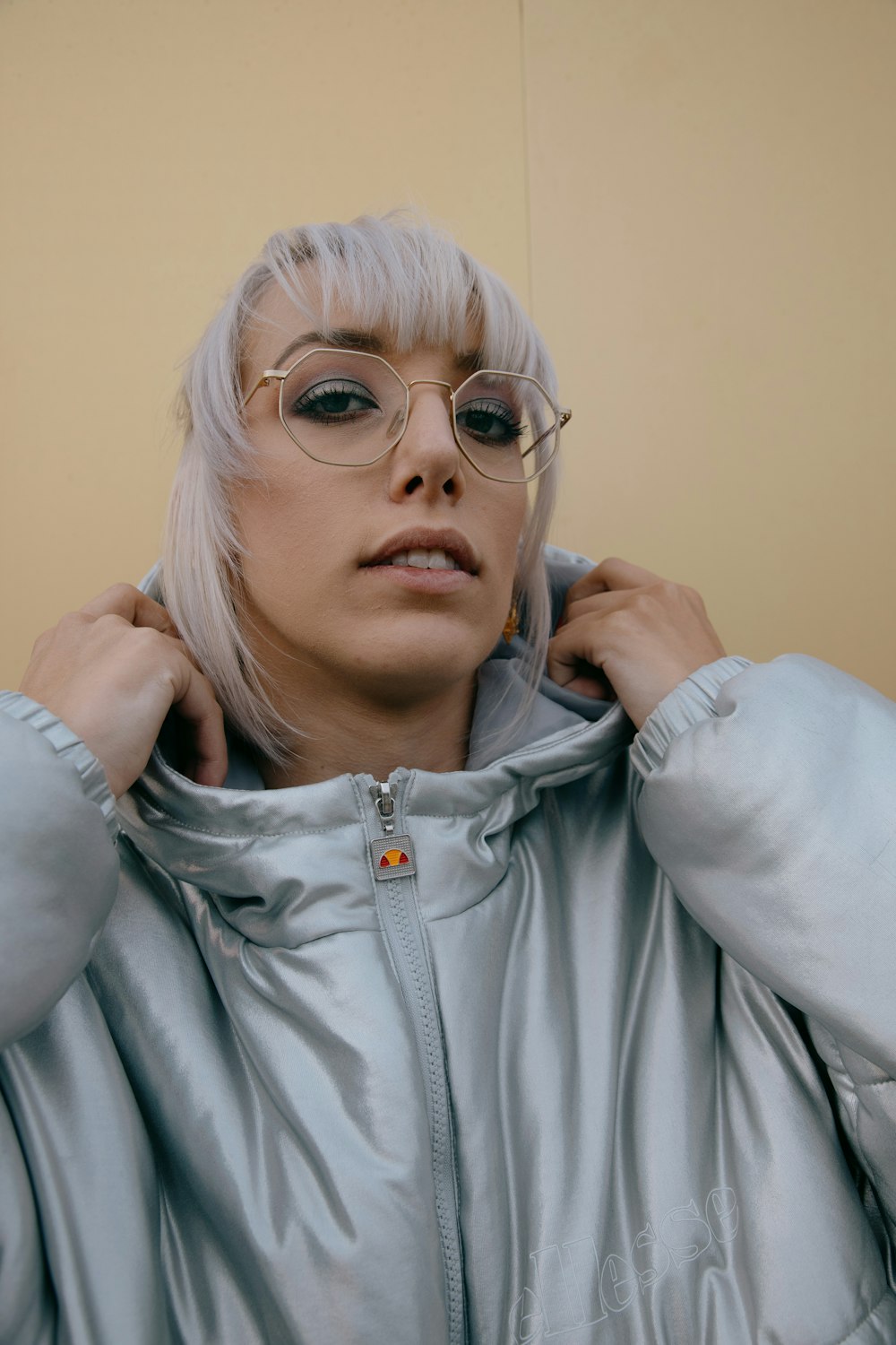 woman in gray zip up jacket wearing silver framed eyeglasses