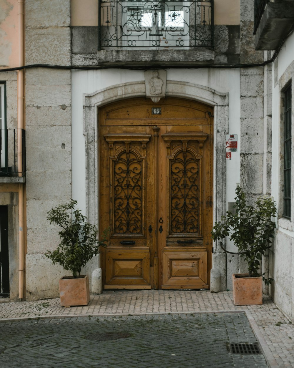 Porta di legno marrone su edificio in cemento bianco
